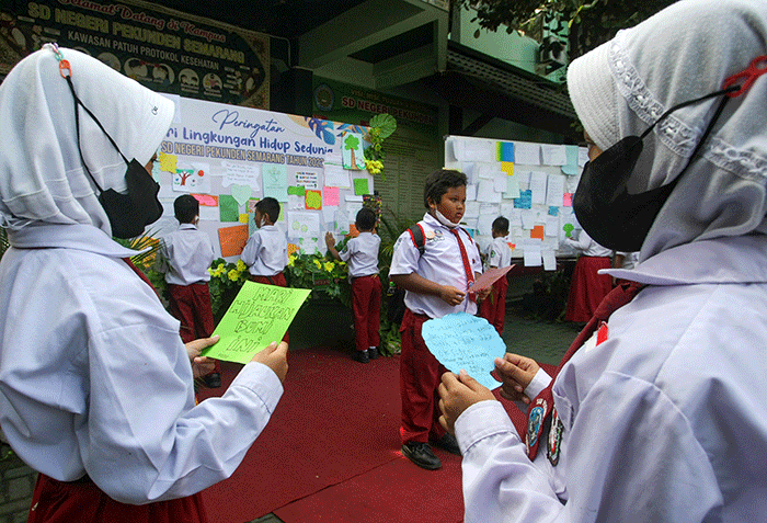 Sejumlah siswa menempelkan tulisan sebuah harapan untuk ekosistem lingkungan pada mading sekolah di kompleks SD Negeri Pekunden Semarang, Jawa Tengah.