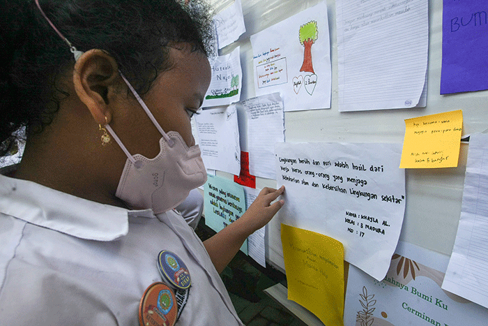 Sejumlah siswa menempelkan tulisan sebuah harapan untuk ekosistem lingkungan pada mading sekolah di kompleks SD Negeri Pekunden Semarang, Jawa Tengah.