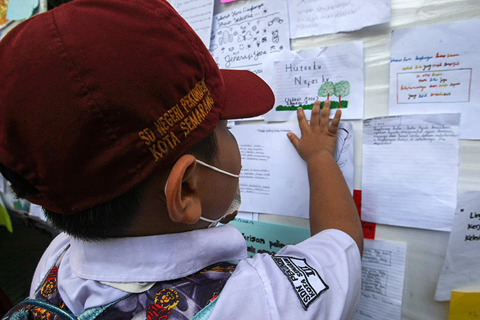 Sejumlah siswa menempelkan tulisan sebuah harapan untuk ekosistem lingkungan pada mading sekolah di kompleks SD Negeri Pekunden Semarang, Jawa Tengah.