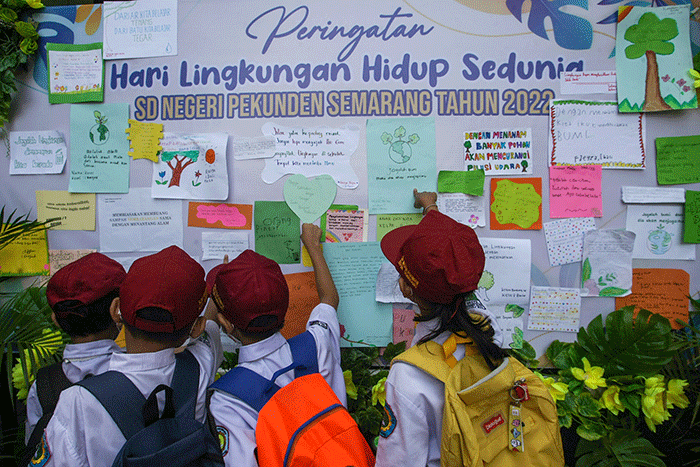 Sejumlah siswa menempelkan tulisan sebuah harapan untuk ekosistem lingkungan pada mading sekolah di kompleks SD Negeri Pekunden Semarang, Jawa Tengah.