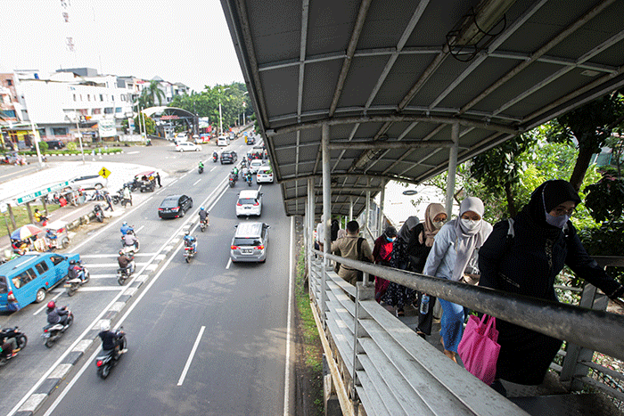 Aktivitas warga saat pulang kerja di Jembatan Penyeberangan Orang (JPO) Tanjung Barat, Jakarta Selatan, Selasa (7/6/2022).