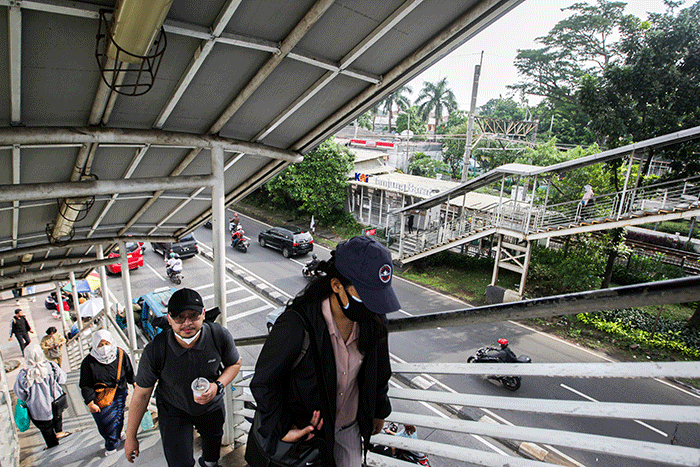 Aktivitas warga saat pulang kerja di Jembatan Penyeberangan Orang (JPO) Tanjung Barat, Jakarta Selatan, Selasa (7/6/2022).