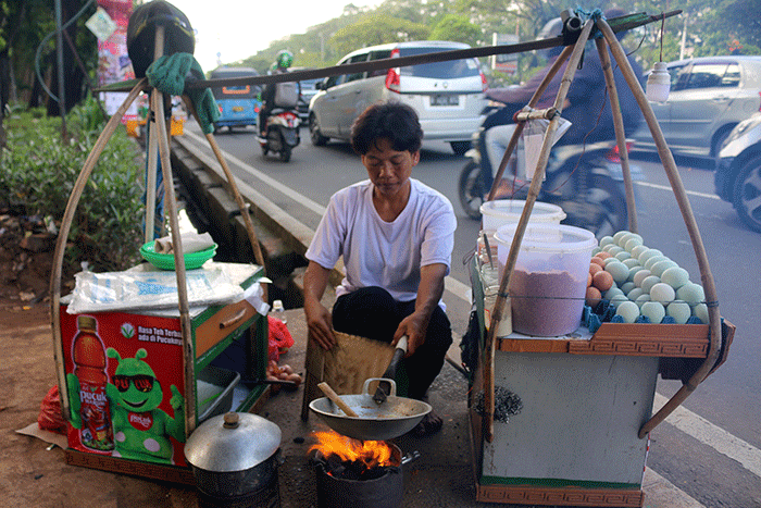 Pedagang membuat kerak telor di kawasan Jalan Benyamin Sueb, Jakarta, Sabtu (11/6/2022).