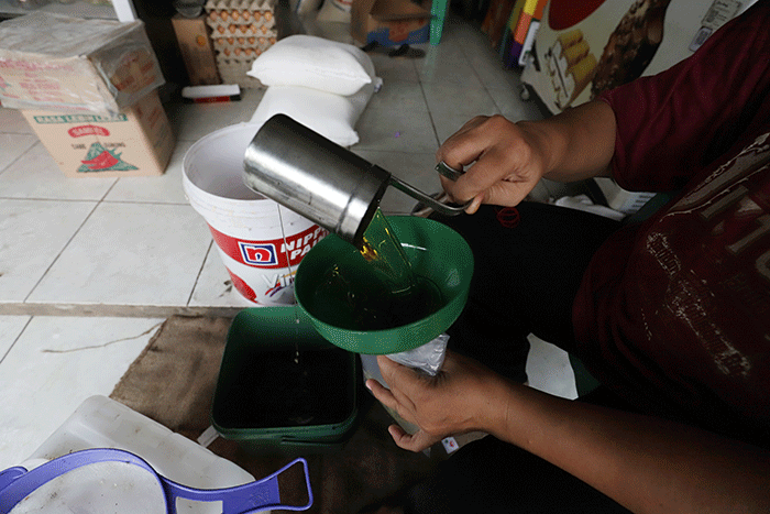 Pedagang mengemas minyak goreng curah di salah satu toko kawasan Kota Bekasi, Jawa Barat, Sabtu (11/6/2022).