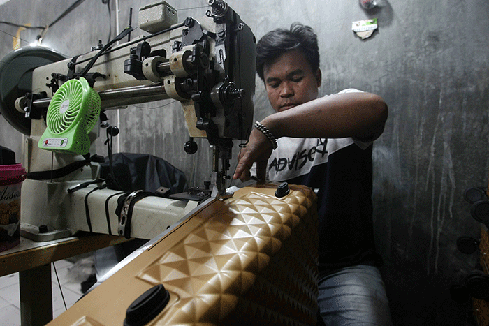 Aktivitas perajin koper fiber, Ghulam Koper di Jalan Ayodyapala Krobokan Semarang tengah memasang roda dan melakukan finishing.