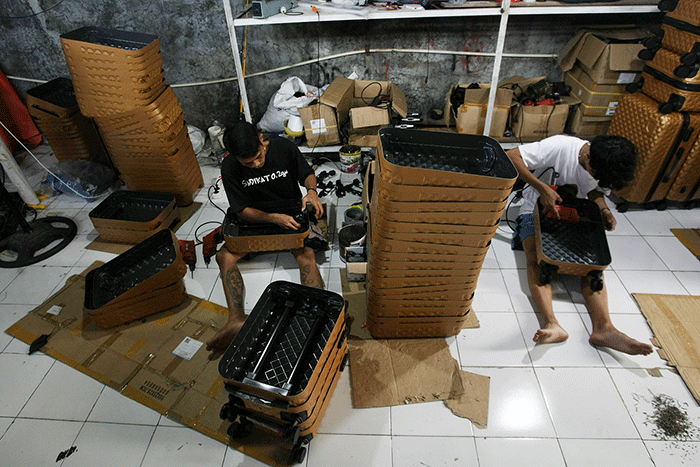 Aktivitas perajin koper fiber, Ghulam Koper di Jalan Ayodyapala Krobokan Semarang tengah memasang roda dan melakukan finishing.