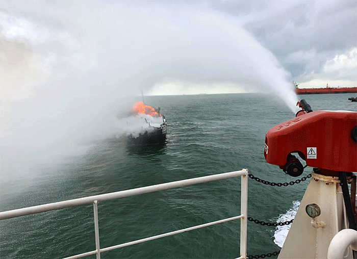KN Pulau Dana-323 Bakamla RI melaksanakan pemadaman KM Bintang Surya yang terbakar di Perairan Karimun, Selat Malaka, Riau, Minggu (12/6/2022).