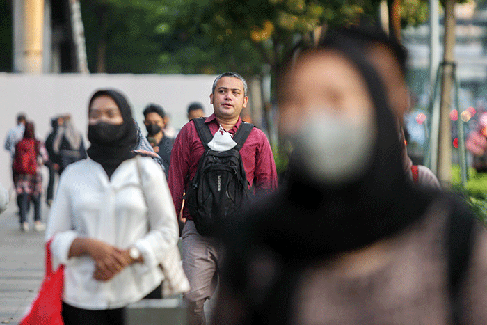Sejumlah pekerja melintasi pedestrian di kawasan Dukuh Atas, Jakarta Pusat, Senin (20/6/2022).