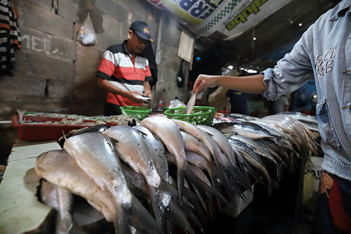 Pedagang ikan laut melayani pembeli di Pasar Kecapi, Kota Bekasi, Jawa Barat, Selasa (21/6/2022).
