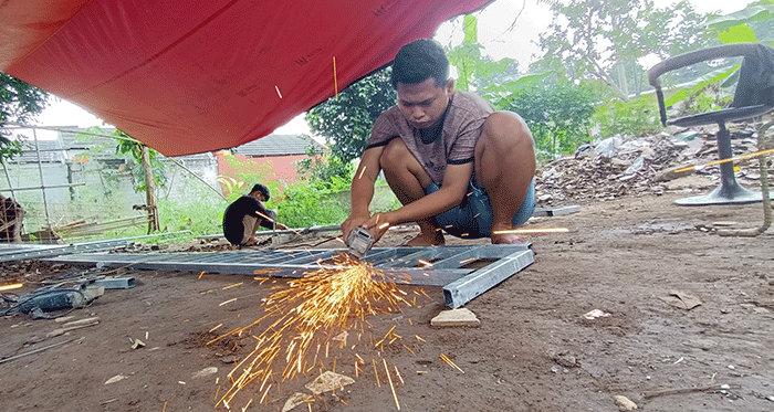 Pekerja menyelesaikan pembuatan pagar di salah satu UMKM kawasan Kota Bekasi, Jawa Barat, Senin (27/6/2022).