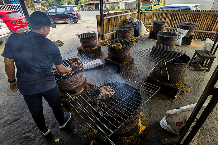 Pekerja sedang mengolah ayam bakar dan ikan bakar di salah satu tempat makan di kawasan Tangerang, Selasa, (28/6/2022).