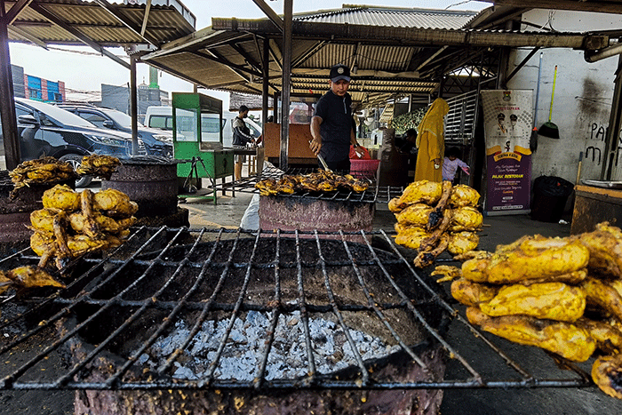 Pekerja sedang mengolah ayam bakar dan ikan bakar di salah satu tempat makan di kawasan Tangerang, Selasa, (28/6/2022).
