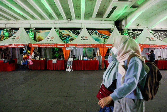 Sejumlah warga berjalan melintasi mural di Terowongan Kendal, Sudirman, Jakarta, Rabu (29/6/2022).