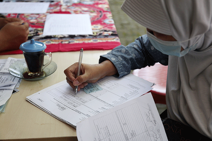 Petugas pelayanan keliling Dinas Kependudukan dan Pencatatan Sipil Provinsi DKI Jakarta membantu warga untuk mengurus data.