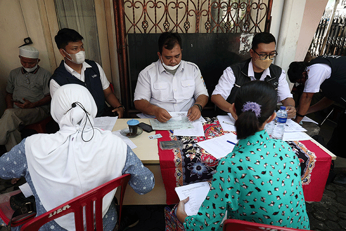 Petugas pelayanan keliling Dinas Kependudukan dan Pencatatan Sipil Provinsi DKI Jakarta membantu warga untuk mengurus data.