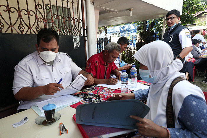 Petugas pelayanan keliling Dinas Kependudukan dan Pencatatan Sipil Provinsi DKI Jakarta membantu warga untuk mengurus data.