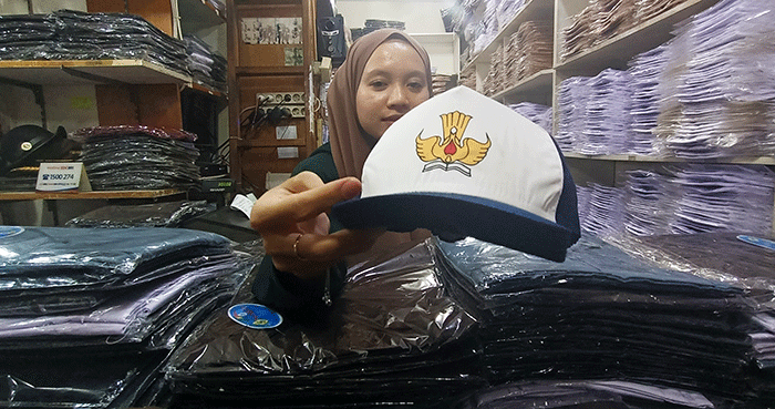 Penjual seragam sekolah melayani pembeli di Pasar Pondok Gede, Kota Bekasi, Jawa Barat, Jumat (8/7/2022).