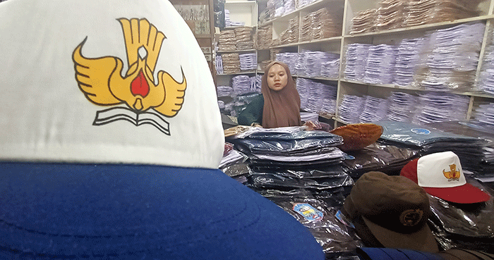 Penjual seragam sekolah melayani pembeli di Pasar Pondok Gede, Kota Bekasi, Jawa Barat, Jumat (8/7/2022).
