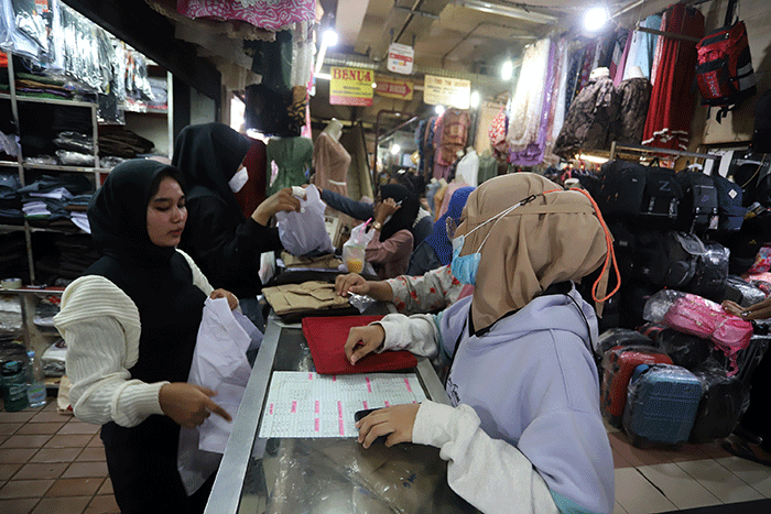 Orang tua memilih seragam sekolah baru untuk anaknya di salah satu kios di Pasar Kebayoran Lama, Jakarta, Sabtu (9/7/2022).