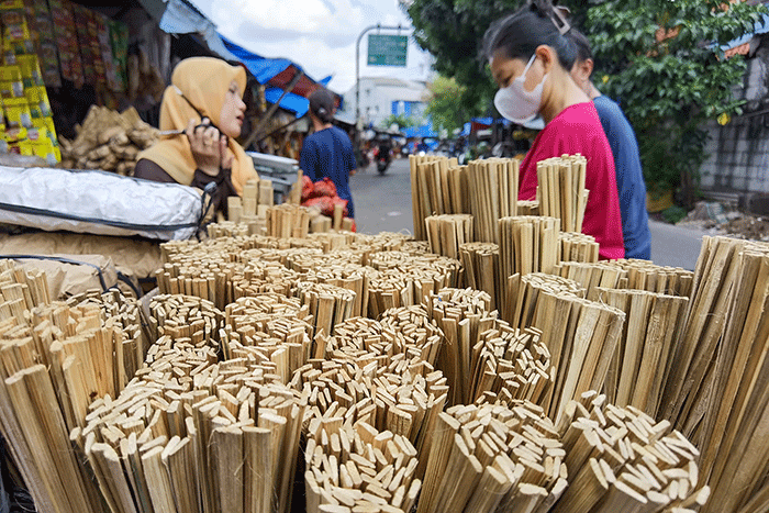 Pedagang saat melayani pembeli perlengkapan membuat sate di Jakarta Barat, Minggu (10/7/2022).