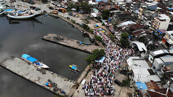 Foto udara sejumlah umat muslim menunaikan ibadah salat Idul Adha 1443 H di Pelabuhan Paotere Makassar, Minggu (10/7/2022).