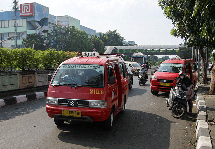 Penumpang menggunakan angkutan umum (angkot) di Jakarta, Selasa (12/7/2022).