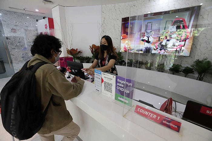 Petugas melayani pelanggan di Galeri Smartfren di kawasan Jalan Sabang, Jakarta, Kamis (14/7/2022).