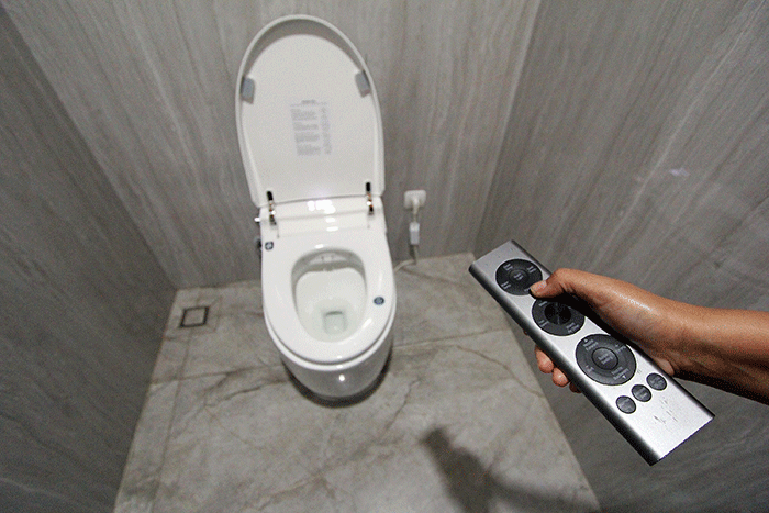 Petugas kebersihan mengoprasikan Smart Closet yang berada di dalam toilet di Rest Area Banjaratna Brebes, Jawa Tengah, Jumat (15/7/2022).