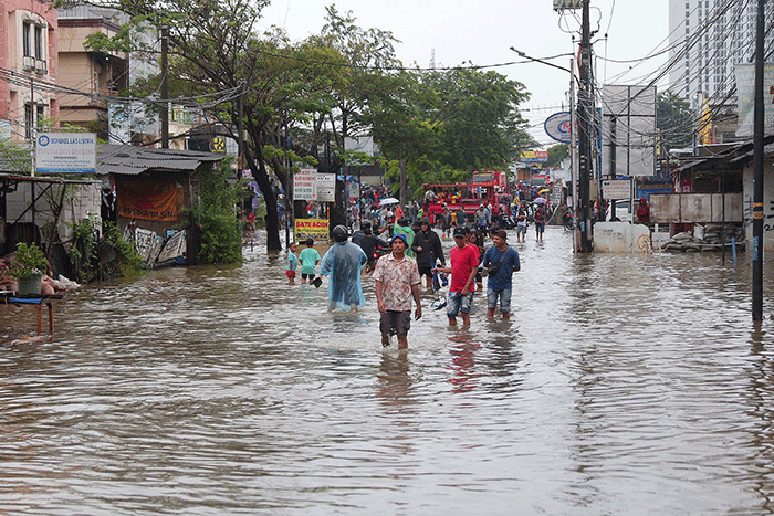 Warga melintasi banjir yang menggenangi Jalan KH Hasyim Ashari, Kota Tangerang, Banten, Sabtu (16/7/2022).