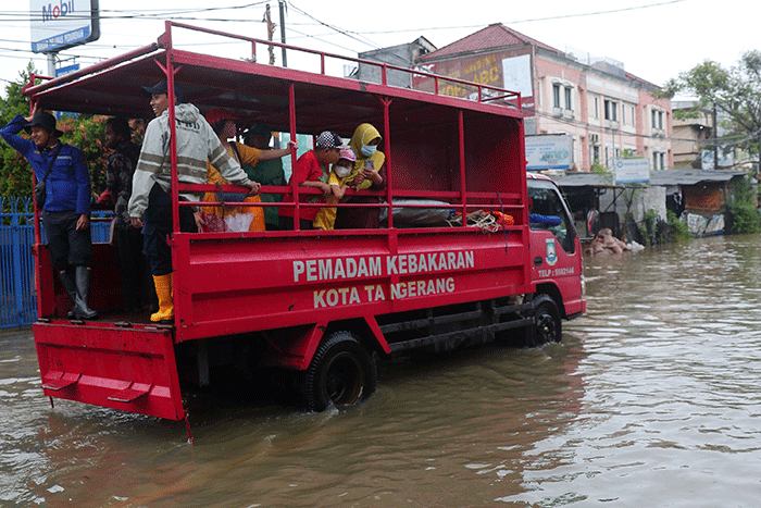 Warga melintasi banjir yang menggenangi Jalan KH Hasyim Ashari, Kota Tangerang, Banten, Sabtu (16/7/2022).