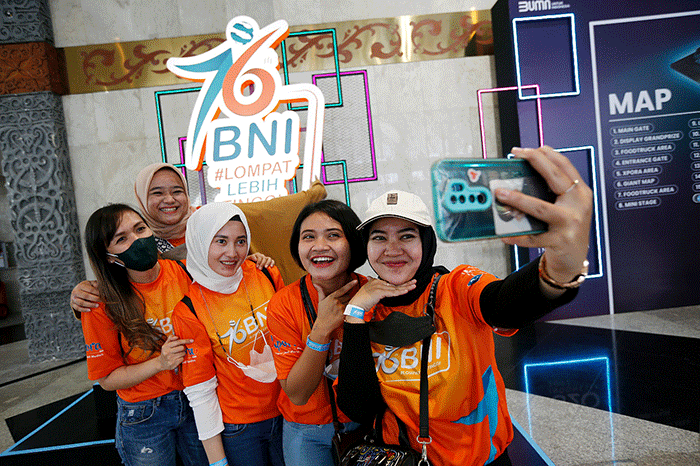 Pengunjung swafoto BNI Mobile Banking dan BNIDirect di sela-sela BNI keceriaan konser musik Loud Fest 2022 di Jakarta Convention Center, Minggu (17/7/2022).