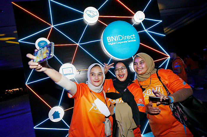 Pengunjung swafoto BNI Mobile Banking dan BNIDirect di sela-sela BNI keceriaan konser musik Loud Fest 2022 di Jakarta Convention Center, Minggu (17/7/2022).