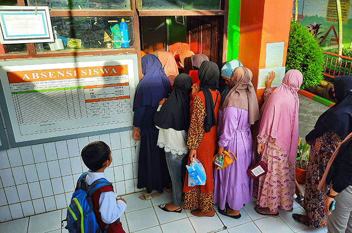 Sejumlah pengantar anak sekolah menunggu di depan kelas sekolah SDN Inpres Perumnas Antang, Makassar, Senin (18/7/2022).