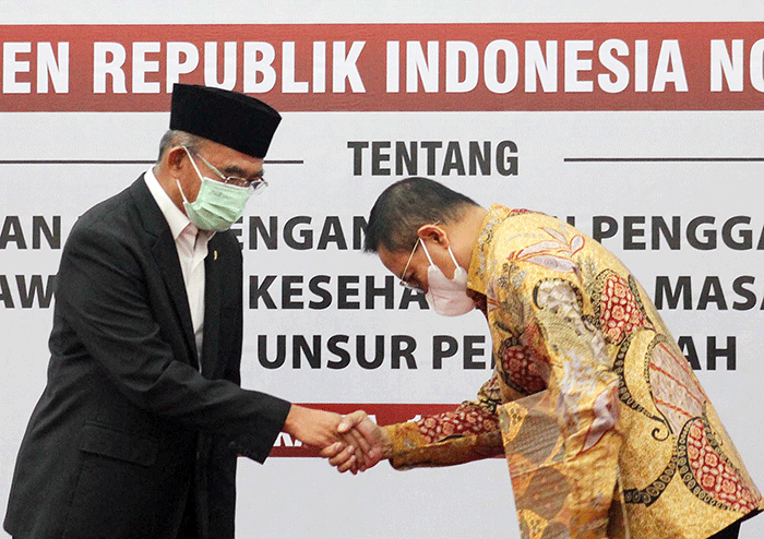 Menko PMK Muhadjir Effendy (kiri) mengangkat Ketua Dewas BPJS Kesehatan Abdul Kadir masa jabatan tahun 2021-2026, di Jakarta, Senin, (18/7/2022).