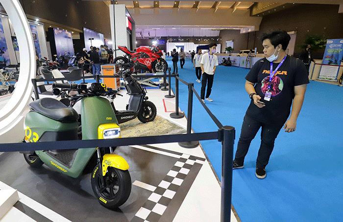 Pengunjung melihat motor dan mobil listrik yang dipamerkan dalam acara PERIKLINDO Electric Vehicle Show (PEVS) 2022 di JIEXPO Kemayoran, Jakarta Pusat.