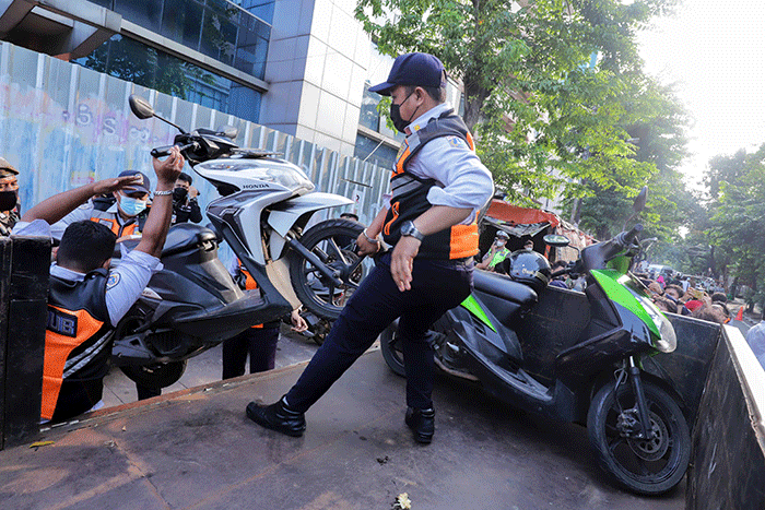 Sejumlah petugas gabungan yang terdiri dari Satpol PP dan Dinas Perhubungan (Dishub) DKI Jakarta memindahkan sepeda motor yang terparkir liar ke atas truk.