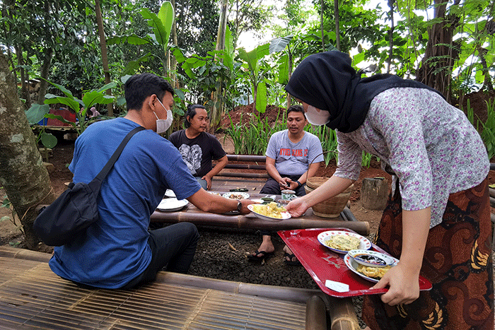 Pengunjung saat menikmati makanan yang di sajikan dengan suasana Tempat berkonsep menyatu dengan alam di Tangerang Selatan, Minggu (7/8/2022).