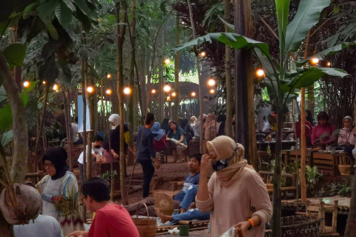 Pengunjung saat menikmati makanan yang di sajikan dengan suasana Tempat berkonsep menyatu dengan alam di Tangerang Selatan, Minggu (7/8/2022).