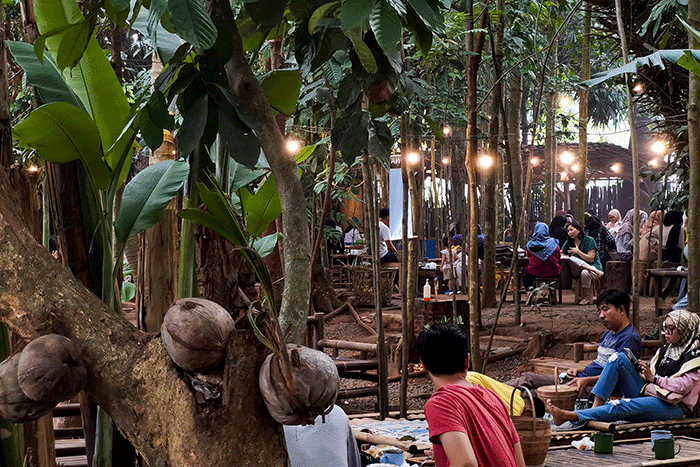 Pengunjung saat menikmati makanan yang di sajikan dengan suasana Tempat berkonsep menyatu dengan alam di Tangerang Selatan, Minggu (7/8/2022).