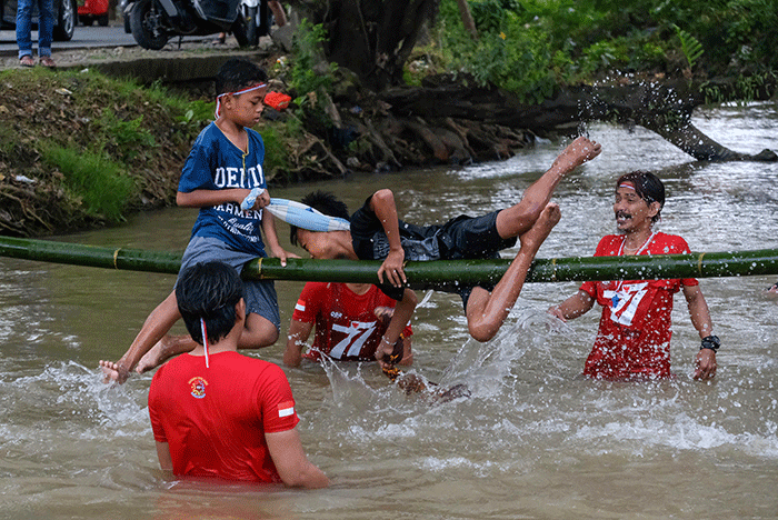 Peserta lomba pukul bantal saling memukul di sungai Tello, Makassar, Minggu (14/8/2022).