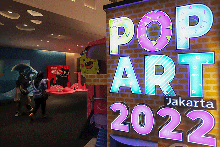 Pengunjung melihat instalasi seni yang dipamerkan pada Pop Art Jakarta di Senayan Park, Jakarta Selatan, Selasa (16/8/2022).