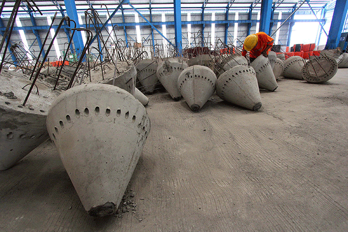 Pekerja melakukan pimindahan Spun Pile atau paku beton di Plant Gasing, pabrik pembuatan khusus beton PT Waksita Beton Precast Tbk di Banyuasin.