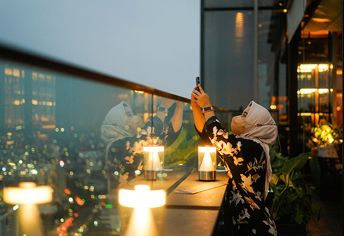 Pengunjung saat menikmati keindahan sore Ibu Kota di Kita Bar, Park Hyatt Jakarta, Senin (22/8/2022).
