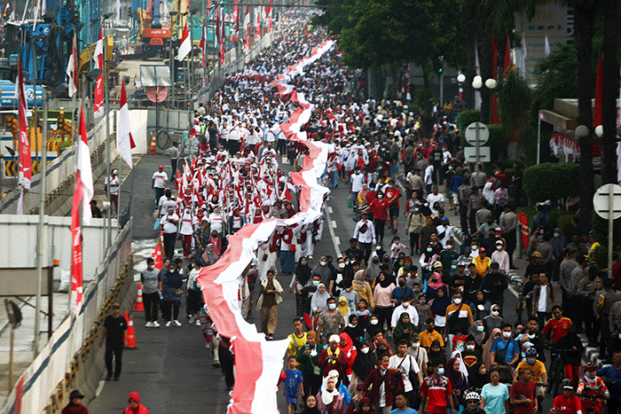 Ratusan warga kompak membawa Bendera Merah Putih sepanjang 1.700 meter di Jakarta, Minggu (28/8/2022).