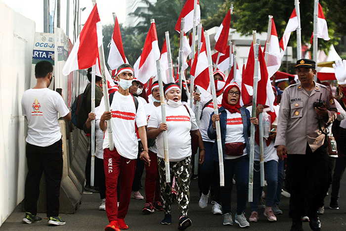 Ratusan warga kompak membawa Bendera Merah Putih sepanjang 1.700 meter di Jakarta, Minggu (28/8/2022).