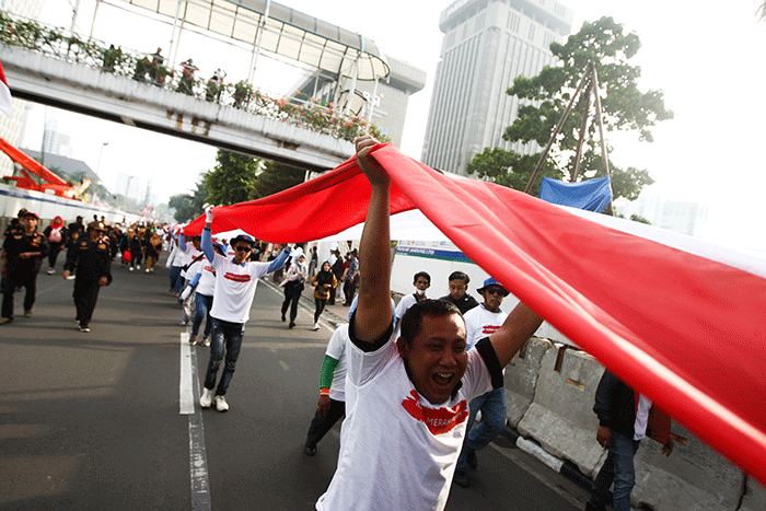 Ratusan warga kompak membawa Bendera Merah Putih sepanjang 1.700 meter di Jakarta, Minggu (28/8/2022).