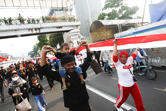 Ratusan warga kompak membawa Bendera Merah Putih sepanjang 1.700 meter di Jakarta, Minggu (28/8/2022).