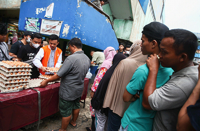 Menteri Perdagangan Zulkifli Hasan (tengah) saat membelikan telur ayam untuk warga di Bazar Pangan Murah, Pasar Minggu, Jakarta, Jumat (2/9/2022).