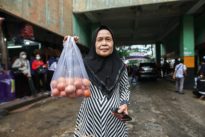 Menteri Perdagangan Zulkifli Hasan (tengah) saat membelikan telur ayam untuk warga di Bazar Pangan Murah, Pasar Minggu, Jakarta, Jumat (2/9/2022).