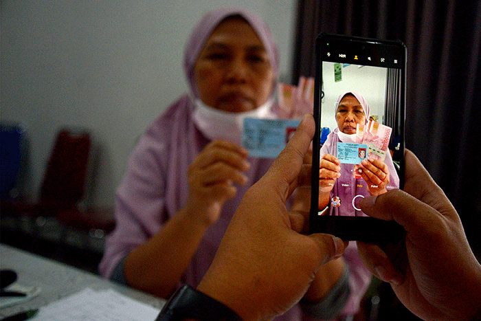 Warga menunjukan uang senilai Rp 300.000 saat pembagian Bantuan Langsung Tunai (BLT) subsidi Bahan Bakar Minyak (BBM) di kawasan Gambir, Jakarta.